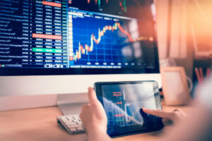 Stocks and shares graphic displayed on tablet and desktop computer