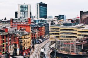 Urban street with historic and new buildings and tram line in Manchester