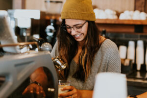 Person making coffee at a coffee shop - photo by Brooke Cagle, via Unsplash